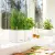 Białe doniczki Cube Color z ziołami na parapecie w kuchni