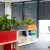 Pomarańczowa donica Office Pot i Monstera w biurze typu open space